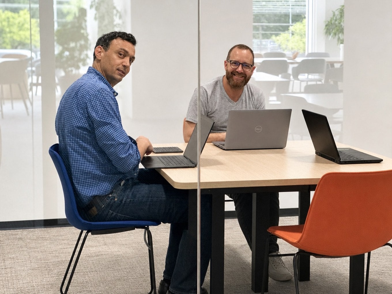 Deux membres de l'équipe travaillant sur leurs ordinateurs portables