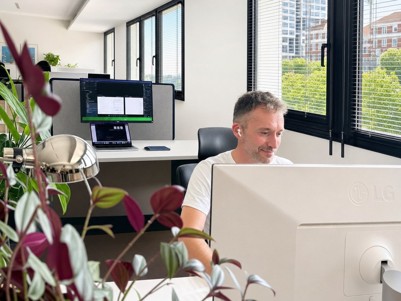 Membre de l'équipe au travail sur iMac, bureaux végétalisés